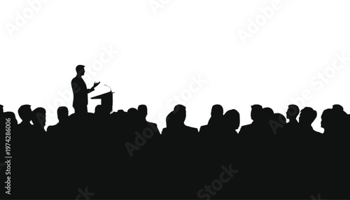 Speaker addressing a large audience from a podium, silhouetted against a bright background with ample copy.