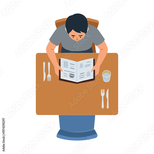 Man sitting at a table reading a menu with utensils and a cup