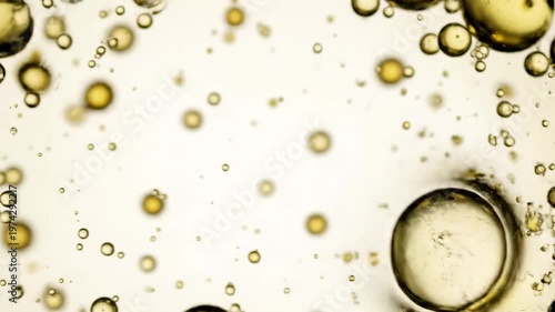 Mesmerizing transformation of golden oil bubbles in liquid suspension