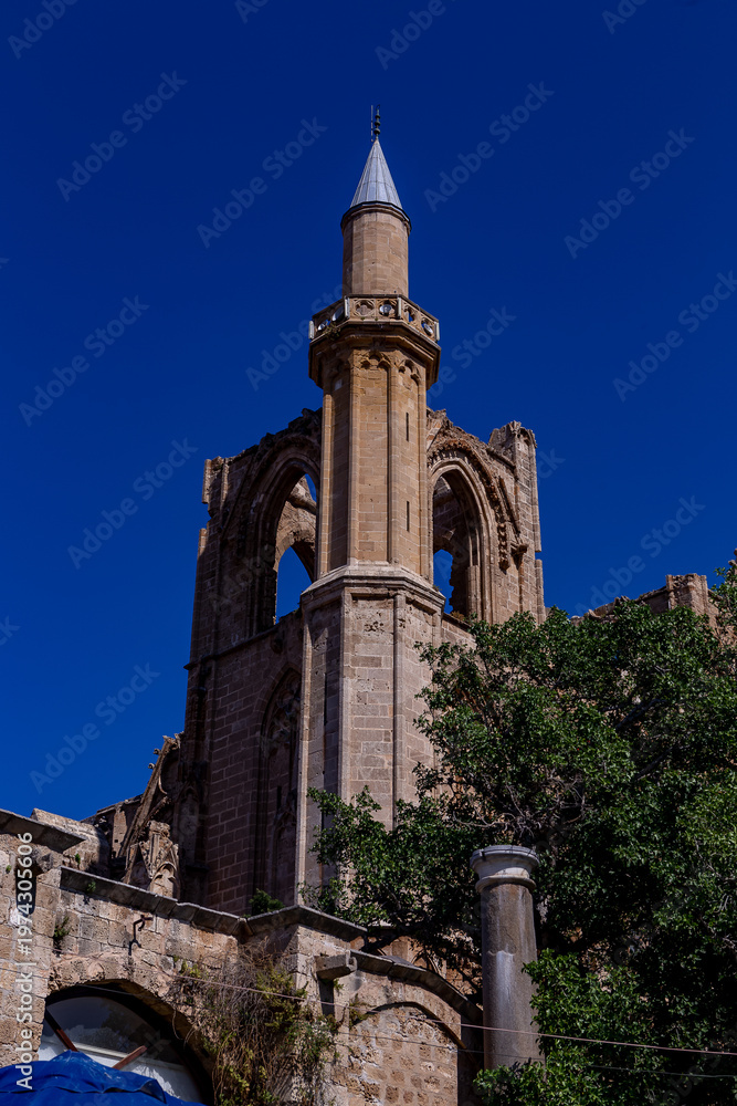 Fototapeta premium The stunning exterior of Lala Mustafa Pasha Mosque (formerly St. Nicholas Cathedral) in Famagusta, Northern Cyprus, showcasing its impressive Gothic architecture, pointed arches, and detailed stonewor