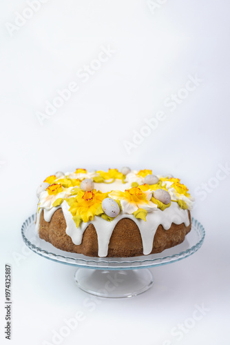 Easter Cake with White Glaze and Yellow Daffodils on Glass Stand