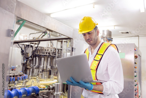 Worker checks on bottle production line in a factory