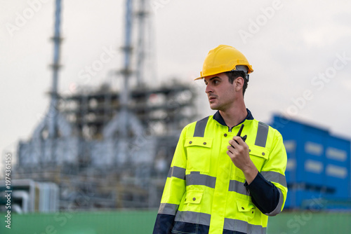 Bild auf Leinwand Caucasian male industrial worker using a walkie-talkie and walk outdoors