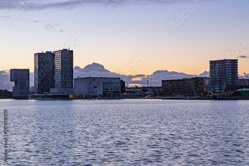 Almere, Netherlands, 14 March 2026. Close-up view of the unique architectural residential buildings and the library along the waterfront of Almere Stad during sunset.