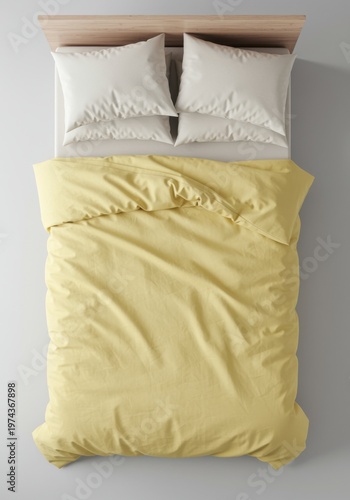 Single bed with pale yellow duvet and white pillows on a grey floor from a top down view for a home interior bedding catalog with copy space
