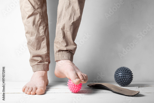 Front view of legs using pink and gray massage balls for foot correction