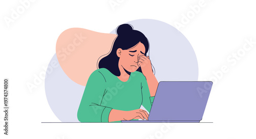 Stressed female worker sits at her laptop computer while rubbing her tired eyes due to exhaustion and digital eye strain.