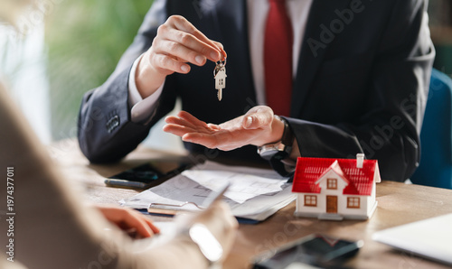 Real Estate Agent Handing Over House Keys to Client ? Home Ownership and Property Purchase Concept