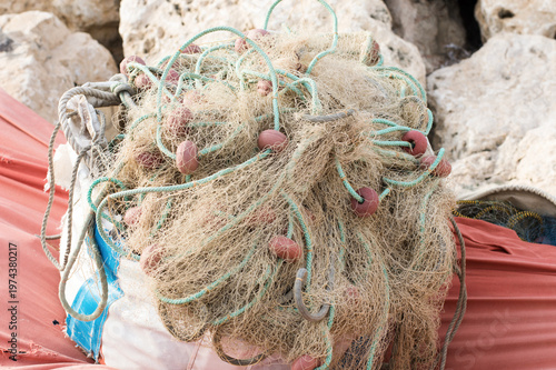Colorful tangled fishing nets with blue floats and ropes close-up, detail of traditional fishing equipment on harbor dock, marine industry background, nautical craftsmanship texture pattern