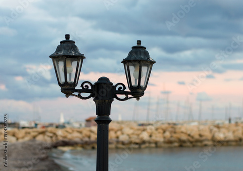 an old lantern against the backdrop of the sunset sky and the sea