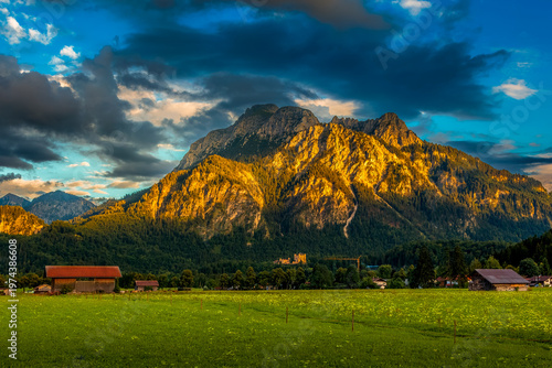 A vibrant landscape view of the Bavarian Alps and meadows during the golden hour.