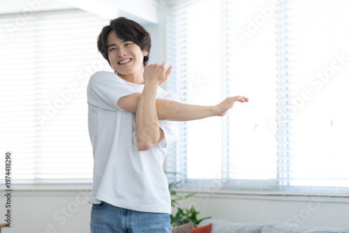 リビングでストレッチをする若い男性