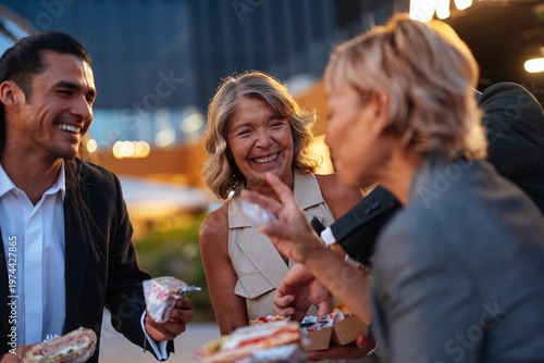 Canvas Print Friends eating street food outdoors at night