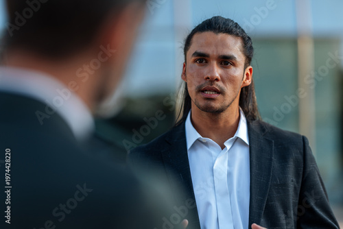 Photos Professional man discussing business issues outdoors with colleague