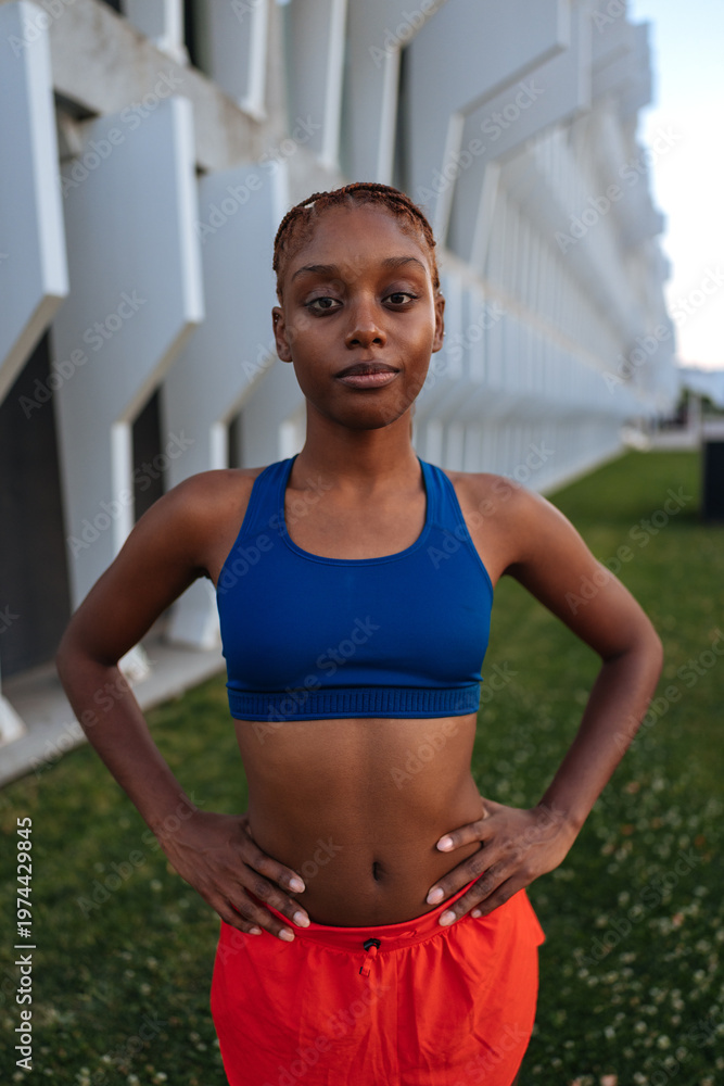 Obraz premium Black woman training outdoors posing with hands on hips
