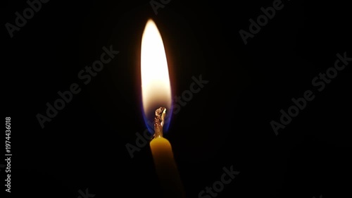 Watch a burning candle as it melts and changes shape in a dark space through four different frames