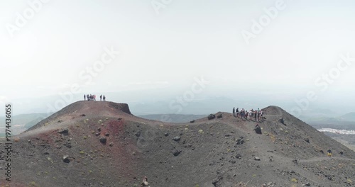 Two groups of tourists standing on a volcanic hill near Etna Volcano, Sicily, 4k