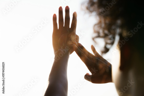 Fotografie Woman applying sunscreen lotion on backhand against golden sunlight