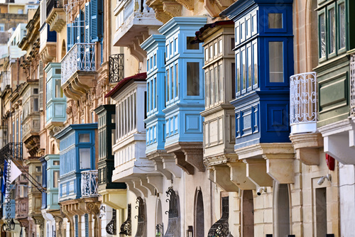 Traditional colorful wooden balconies on a historic limestone building in Valletta, Malta