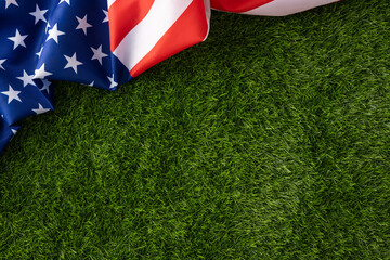 American flag lies on fresh green grass evoking patriotism and national pride suitable for Independence Day July celebrations, Memorial Day tributes, Veteran recognition and seasonal outdoor events