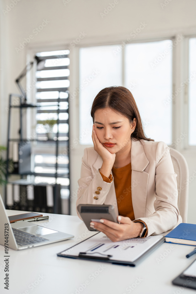 Fototapeta premium Asian businesswoman working with financial documents in office having problems with taxes and accounting.