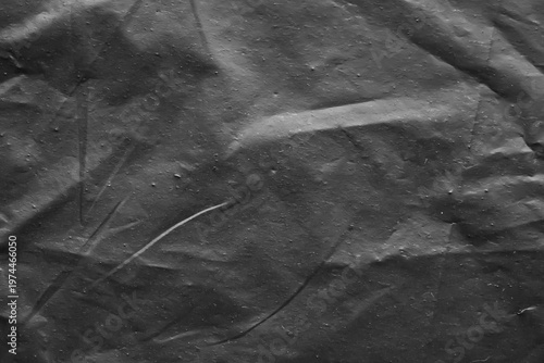 Crumpled Black Plastic Texture Background with Detailed Creases for Dark Design Backdrop