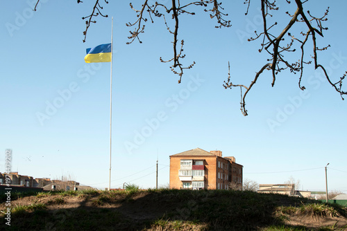Landscape with Ukrainian flag and brick residential building