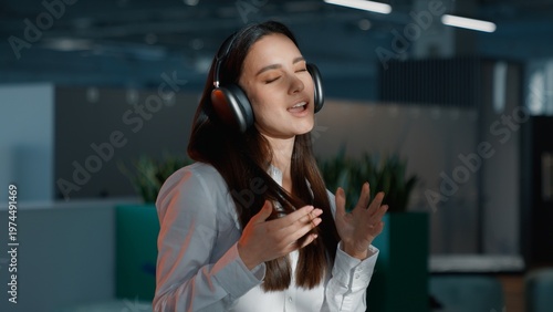 Headshot Caucasian business woman in high quality sound headphones singing listening favorite music businesswoman sing with closed eyes female executive girl listen musical track having fun in office