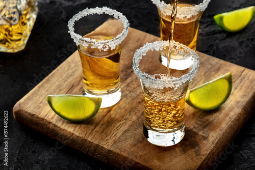 Wallpaper Mural Tequila poured into a shot glass with a salted rim, with lime slices, on a black slate background Torontodigital.ca