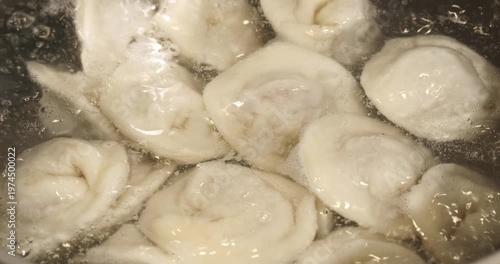 Dumplings being cooked in boiling water, close-up footage.