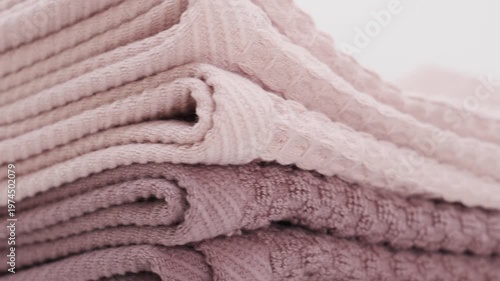 Towels stacked on each other in soft shades at home space to show textures and patterns