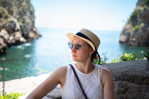 Young woman relaxing on the beach. A moment for yourself while sightseeing. A tourist enjoys the beautiful view.
