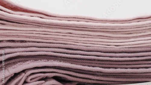 Different types of folded towels displayed in soft colors on a clean surface for home organization in a simple and neat setting