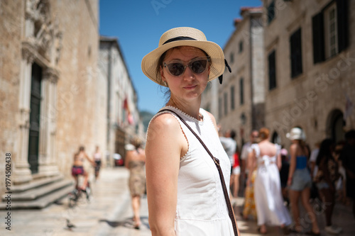 Woman walking in the city. A tourist in a straw hat stands on one of the streets of the old town of Dubrovnik. 