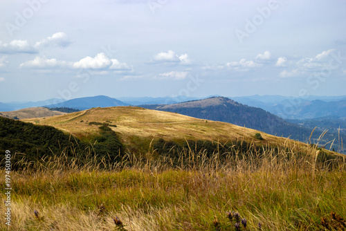 Photos Rolling hills tdry grass distant mountain ranges under soft cloudy sky natural landscape