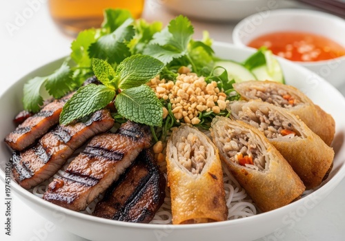 Vietnamese bun thit nuong bowl with grilled pork, crispy spring rolls, fresh herbs, peanuts, and fish sauce