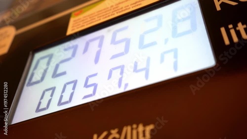 Close-up of a digital gas station fuel pump display showing liters and cost. Concept of energy prices, fuel economy, and transportation costs in a modern industrial setting.