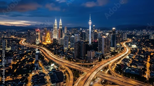 A panoramic aerial night view of Kuala Lumpur skyline, glowing towers and highways stretching across the city, deep blue twilight sky contrasting with warm city lights, dynamic urban composition with