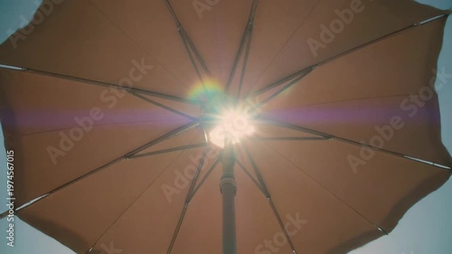 Sunlight peeking through a brown umbrella on a bright day. 4k Footage Video