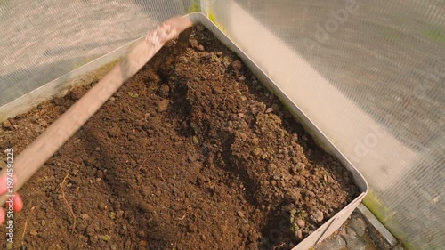 Wallpaper Mural Tilling greenhouse soil with hoe slow motion top view Torontodigital.ca