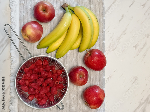 Top view of raspberries bananas and apples. 