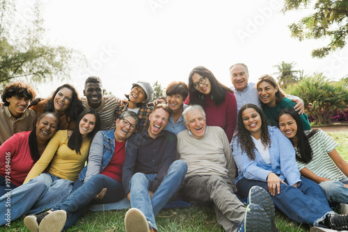Group of multigenerational people smiling in front of camera - Multiracial friends of different ages having fun together - Main focus on center people faces