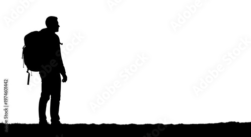 Silhouette of a hiker with a large backpack standing on a grassy hill, looking out.