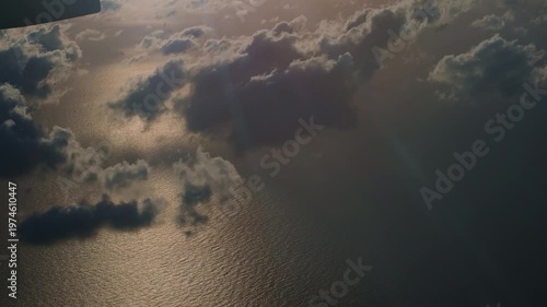 View from an airplane over the sea at dawn in the clouds. 
