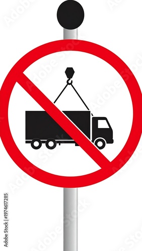 A road sign depicts a truck being lifted by a hook within a red circle crossed by a diagonal line. The sign is mounted on a gray pole
