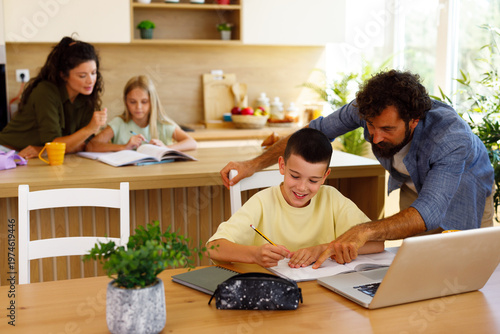 Photos Family homeschooling children learning together in kitchen