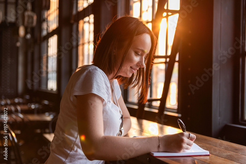 Foto Woman writing in sunlight.