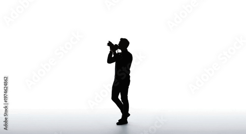 Silhouette of a photographer holding a camera and shooting against a white background