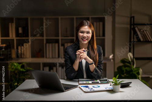 Smiling businesswoman working late at office analyzing data