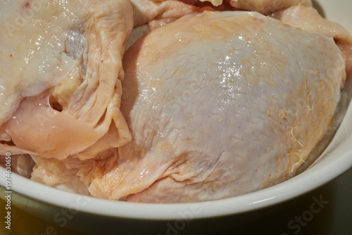Raw, bone-in, skin-on, chicken thighs